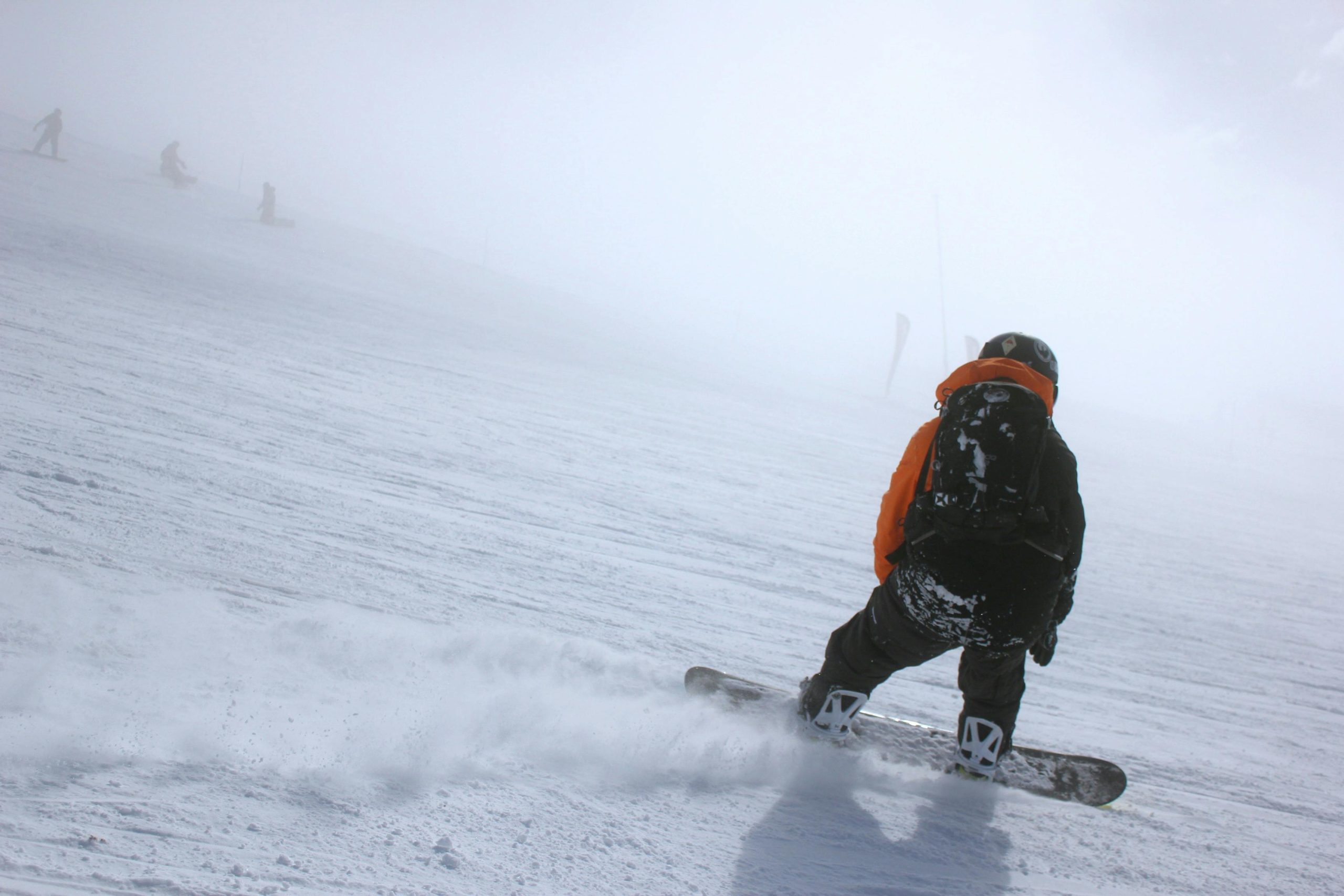 A hardcore snowboarder carving aggressively on steep terrain, showcasing the edge hold and precision engineering of high-performance snowboards.