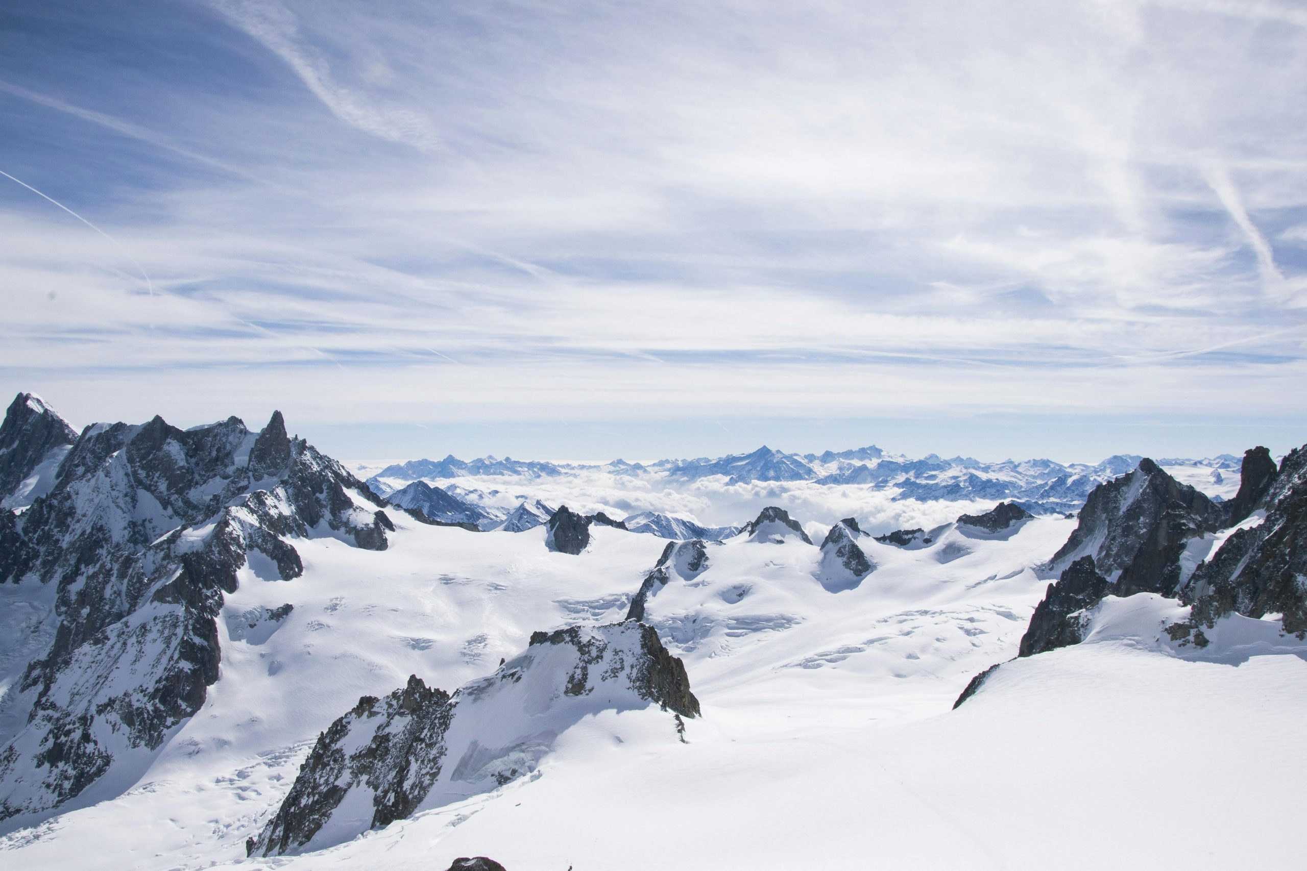A hardcore freerider navigating a steep high-alpine spine wall, demonstrating the advanced snowboard engineering of S-ONE in late-season conditions.