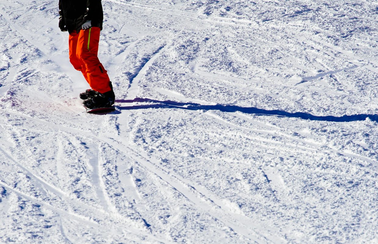 Snowboarder riding down the French Alps, equipped with gear from an integrated manufacturing partner.