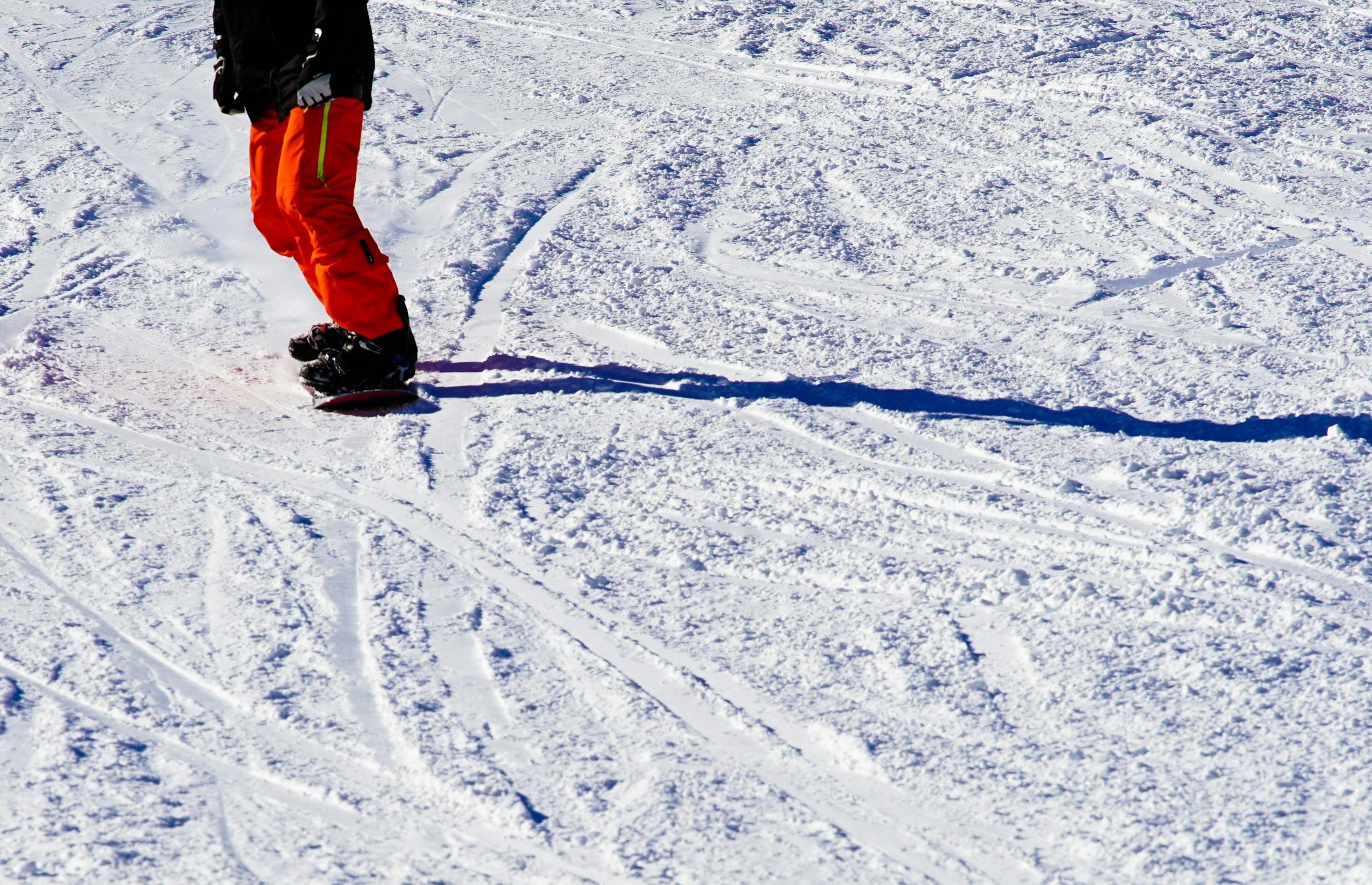 Snowboarder riding down the French Alps, equipped with gear from an integrated manufacturing partner.